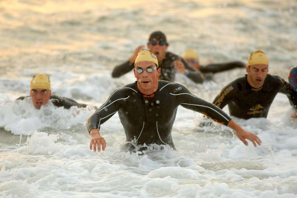 triathletes exhausted after finishing the open water swim