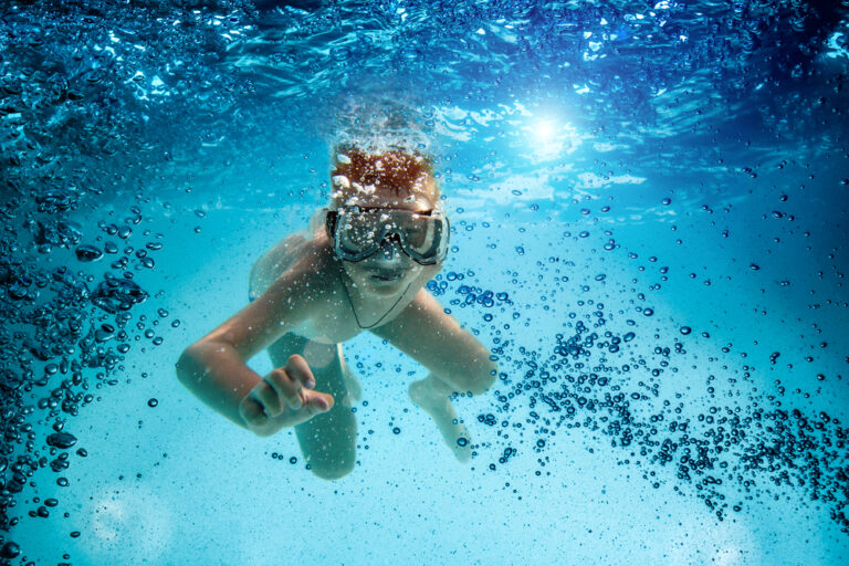 Freedive. Teenager in the mask and snorkel swim underwater.